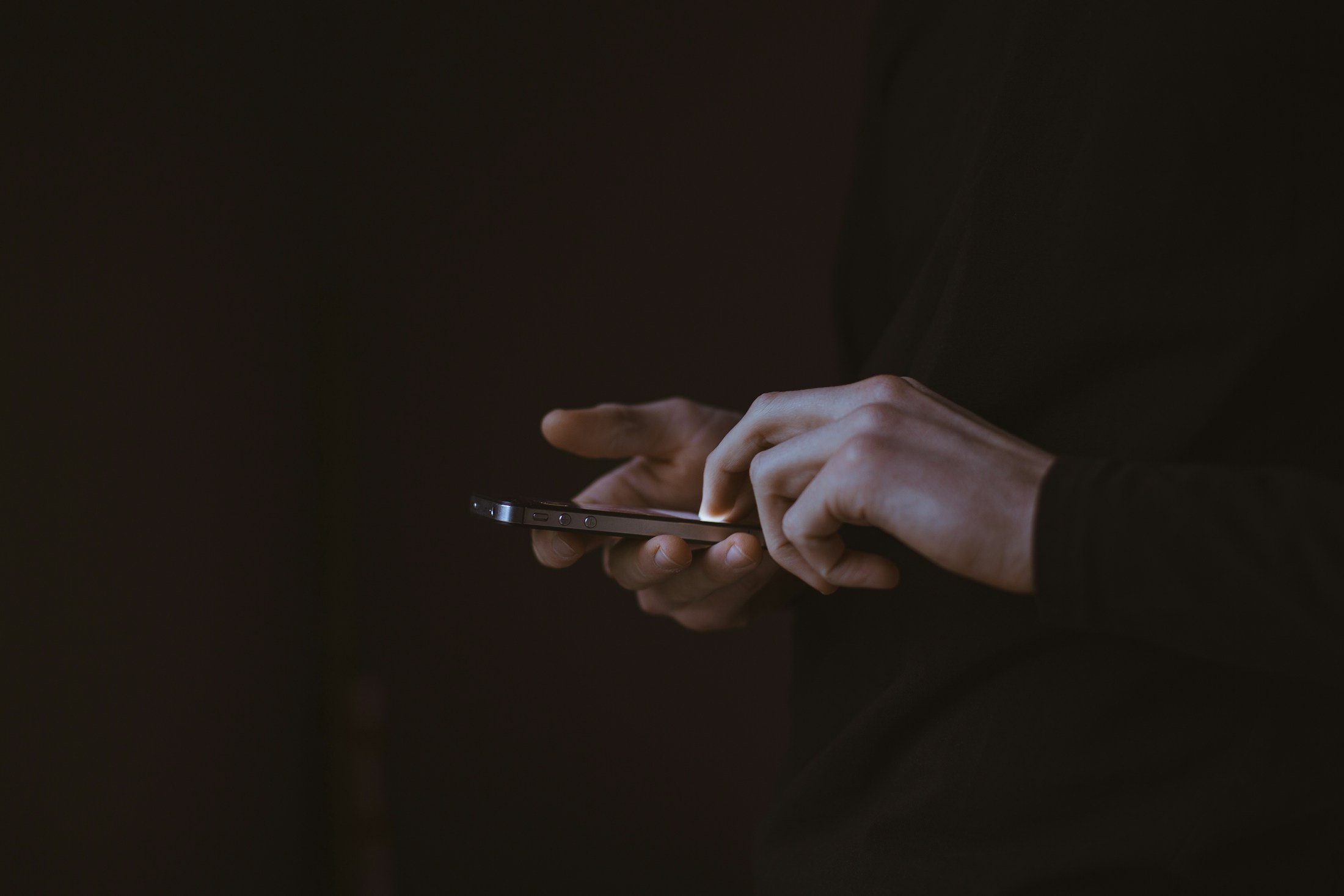 A person using a phone in a quiet, dark setting